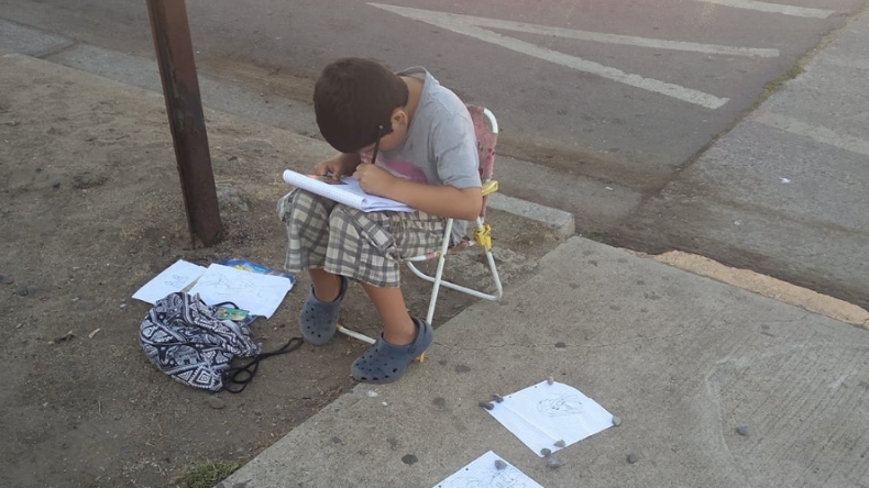 Denuncian que niño debe vender sus dibujos para comprar útiles escolares